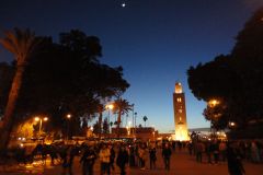 Evening Crowd Walking Toward Koutoubia Mosque and Jemaa el-Fnaa Square in Marrakesh Under Twilight Sky