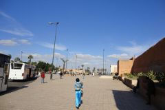 Wide Public Square Near Marrakesh City Walls with Pedestrians and Buses Under Clear Blue Sky