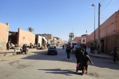 Street Scene Along Marrakesh City Walls with Pedestrians, Cars, and Donkey Carts in Daylight