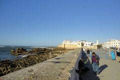 Seafront Ramparts and Coastal Walkway of Essaouira with Pedestrians, Seagulls, and Atlantic Ocean