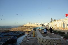 Essaouira Harbor and Seafront Ramparts with Fishing Boats, Pedestrians, and Seagulls at Golden Hour
