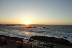 Sunset Over the Atlantic Ocean Seen from Essaouira Ramparts with Rocky Coastline and Golden Light