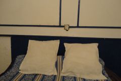 Simple Twin Bed Setup with White Pillows and Blue Patterned Bedding in Modest Interior Room
