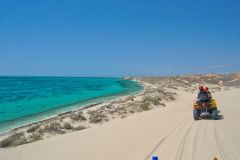 Quad driving at the coast of Coral Bay, Western Australia