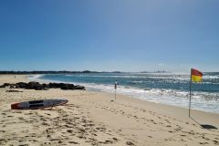 Red and yellow flags at Tallebudgera Beach facing Surfers Paradise