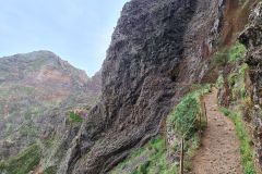 PR1 Vereda do Areeiro narrow ledge trail with rock tunnel near Pico do Arieiro, Madeira, Portugal