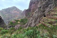 PR1 Vereda do Areeiro trail with rock tunnel and steep cliffs near Pico Ruivo, Madeira, Portugal