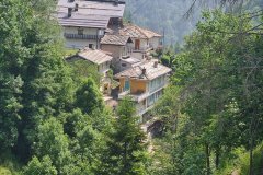 Traditional Hillside Homes Overlooking a Forested Alpine Valley in Northern Italy