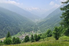 Panoramic View Over a Forested Alpine Valley and Mountain Village in Northern Italy
