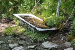 Alpine Spring Water Trough Along Mountain Pasture