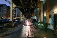 Rain-Soaked Service Alley Beneath Elevated Tracks, Downtown Chicago, Illinois