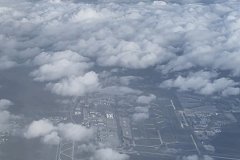 Aerial View from Commercial Aircraft Over Cloud Layer and Airport