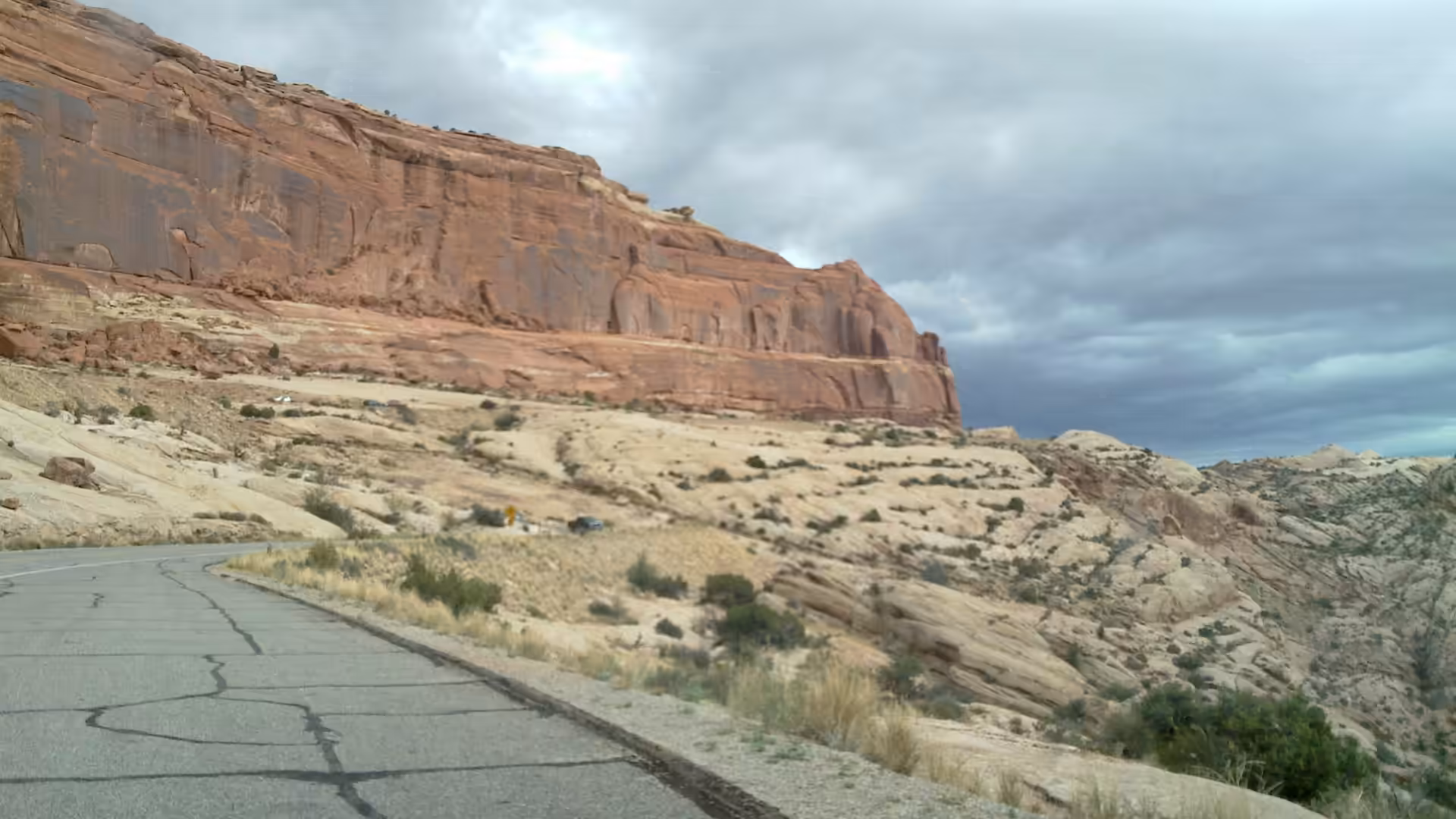 Red rock cliff beside a paved desert road