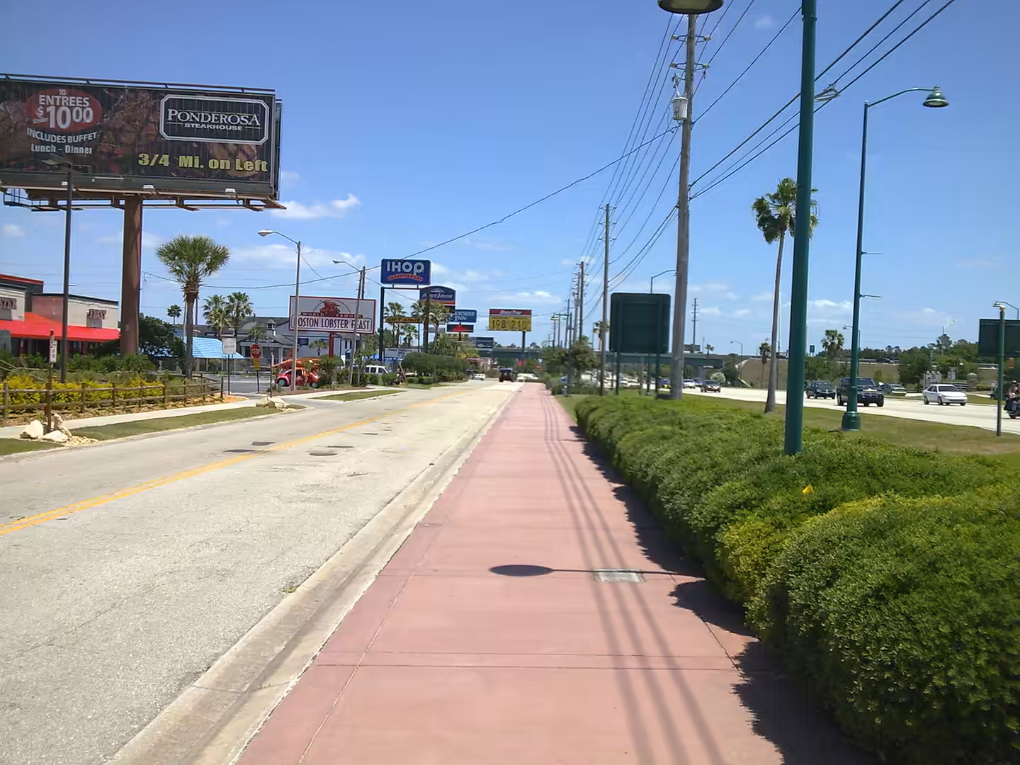 Roadside scene near Orlando, Florida, with restaurant signs including IHOP and Ponderosa along a busy highway.