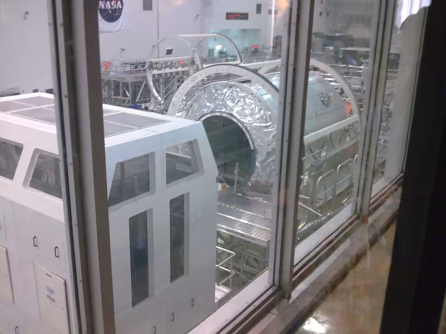 View into a NASA clean room showing spacecraft components under assembly.