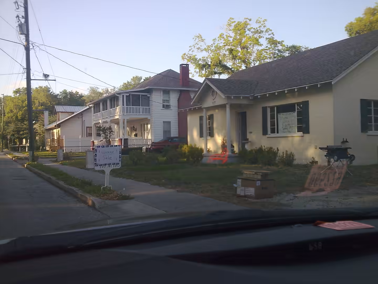Small homes lining a residential street in a Florida neighborhood, viewed from inside a car.
