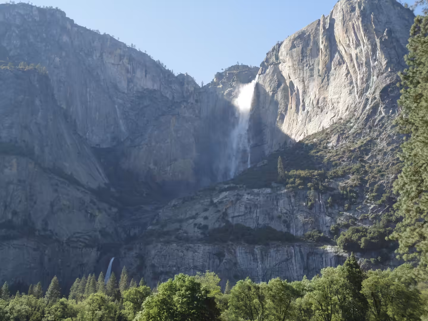Upper Yosemite Falls plunging down sheer granite cliffs above forest