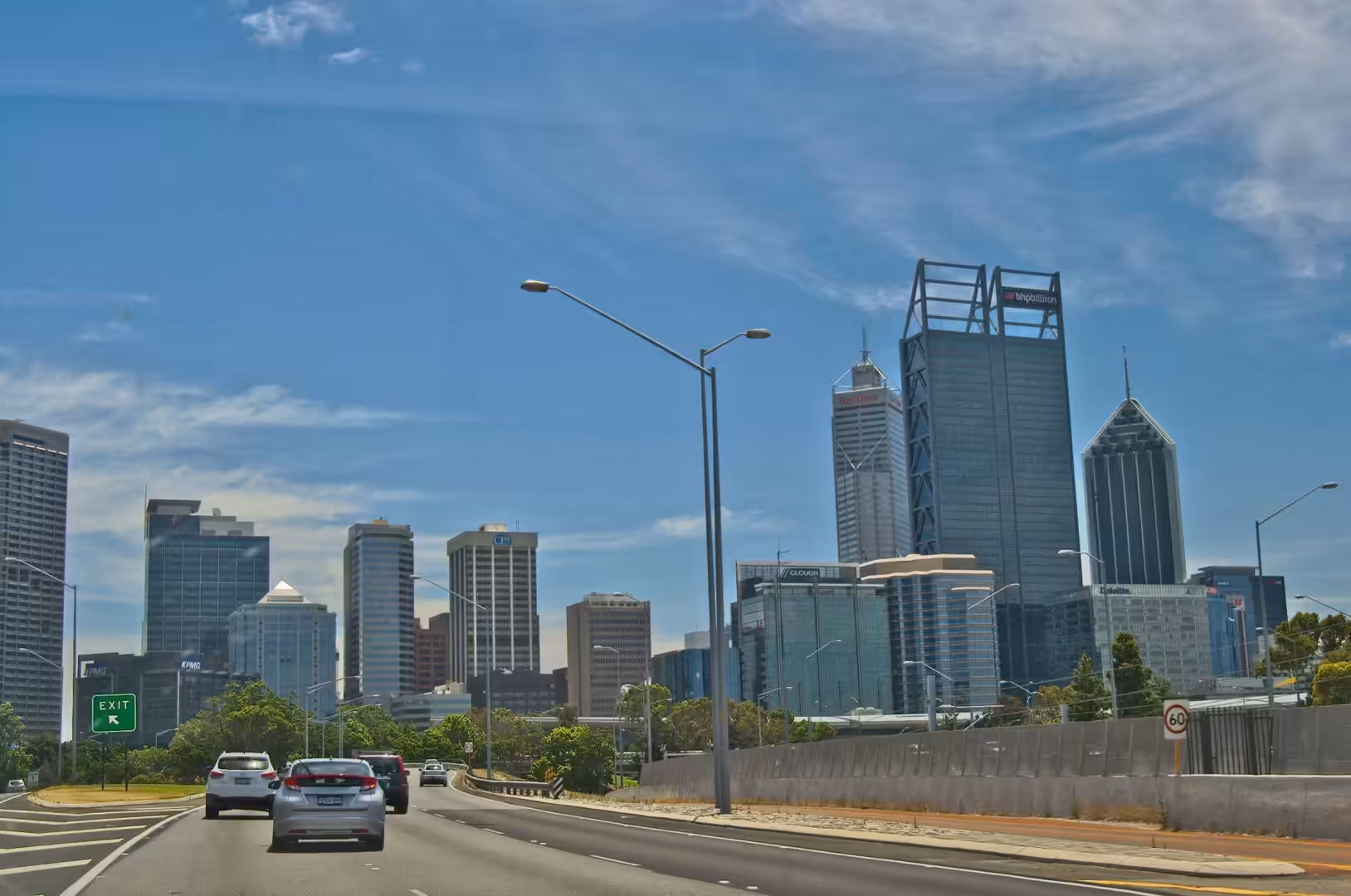 A cluster of rooftops under the highway reveals a modern skyline.