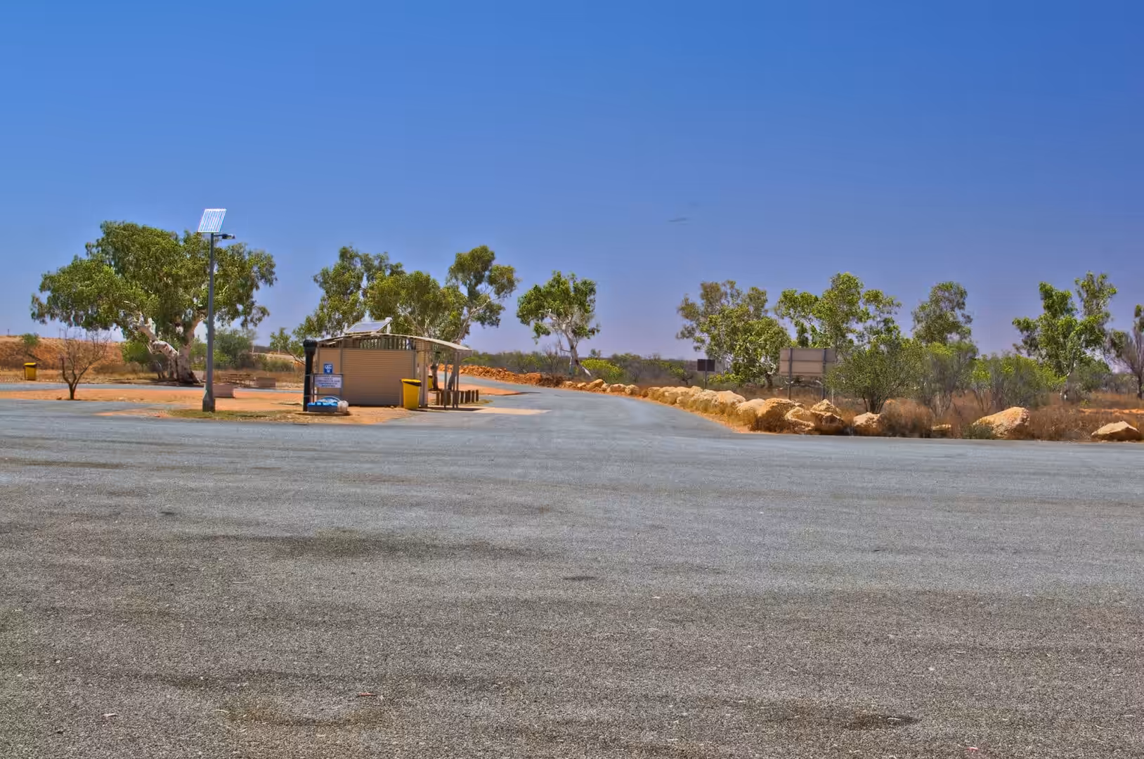 A quiet outback rest stop with a small shelter and eucalyptus trees.
