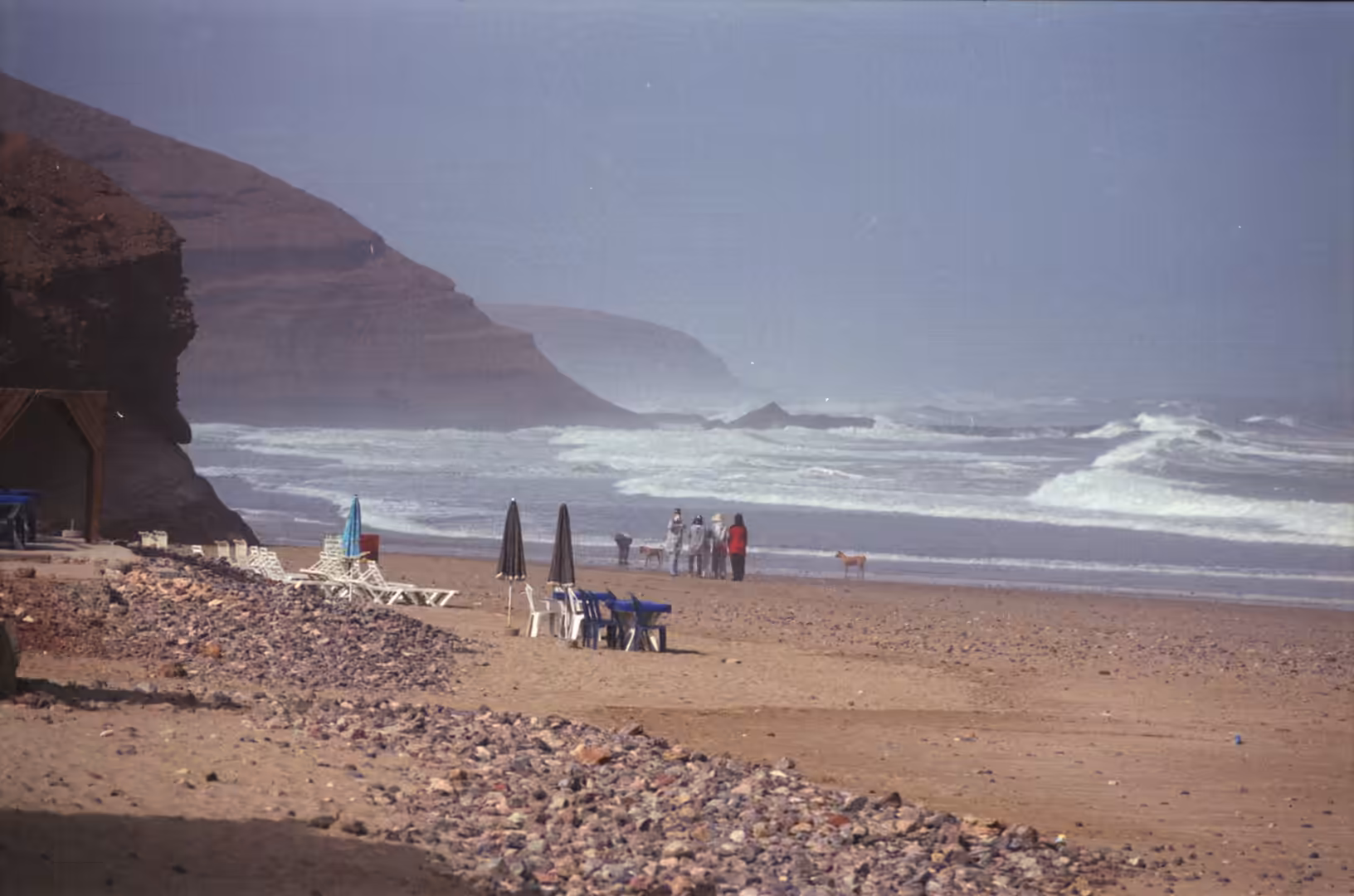 Beach with chairs and umbrellas facing rough Atlantic surf