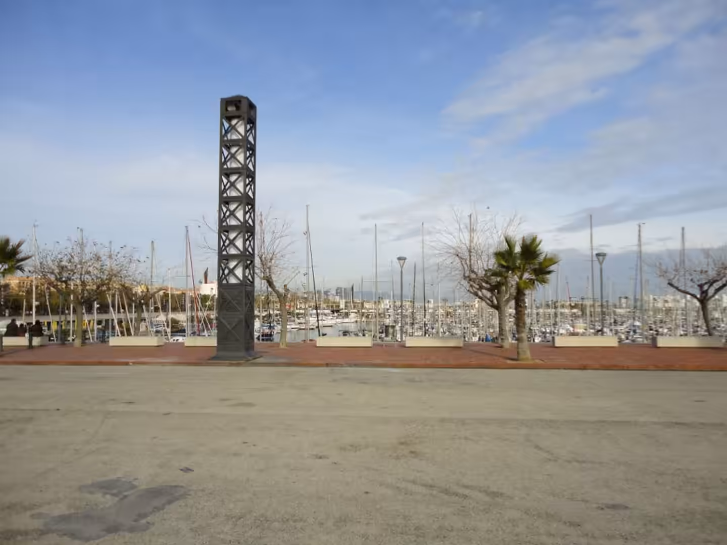 The Cascada Monumental fountain in Parc de la Ciutadella with palm trees, stone terraces, and water jets reflected in a shallow pond.