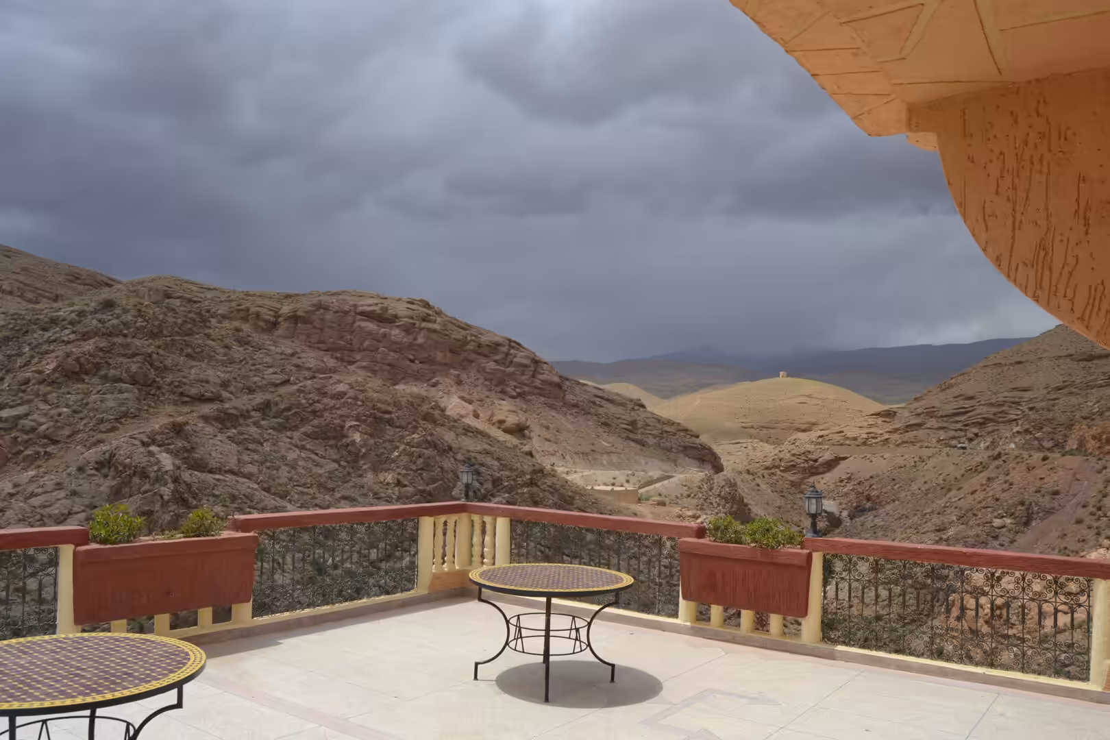 Terrace overlooking rocky desert valley under dramatic storm clouds