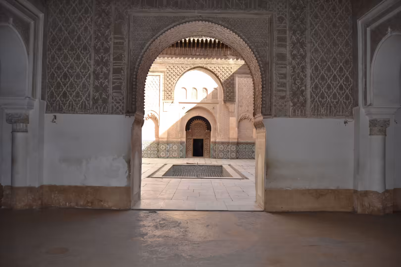 View through an ornate arch into the courtyard of Ben Youssef Madrasa