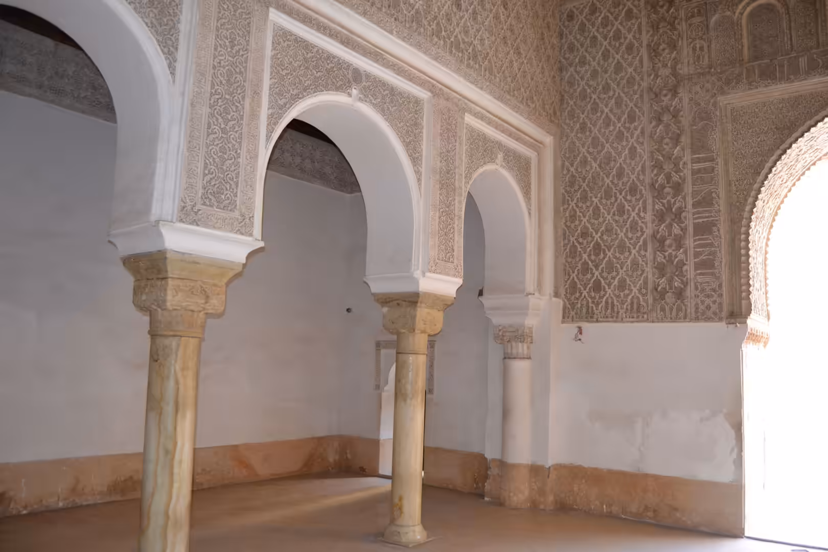 Decorative arches and carved plaster inside Ben Youssef Madrasa