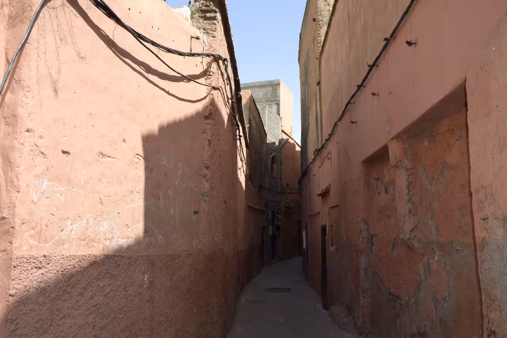Narrow alley with reddish walls in the Medina of Marrakech