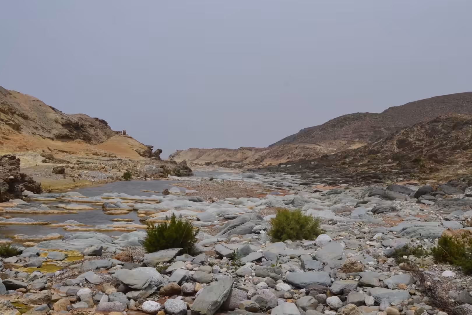 Rocky wadi with shallow water between dry hills south of Sidi Ifni
