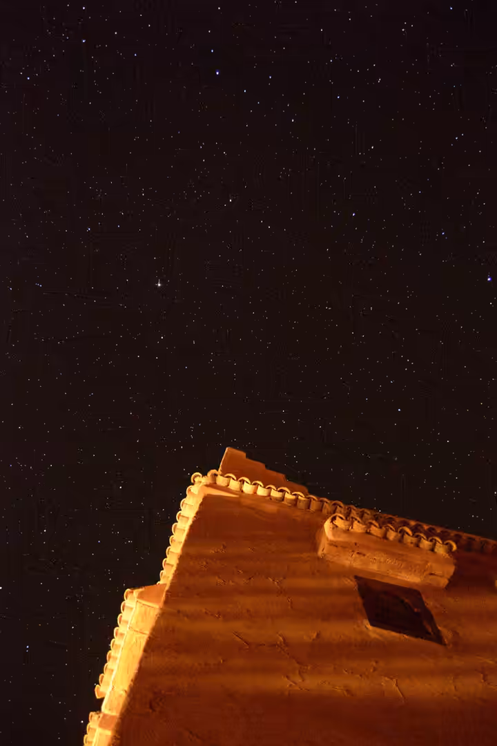 Starry desert sky above traditional adobe house in Morocco