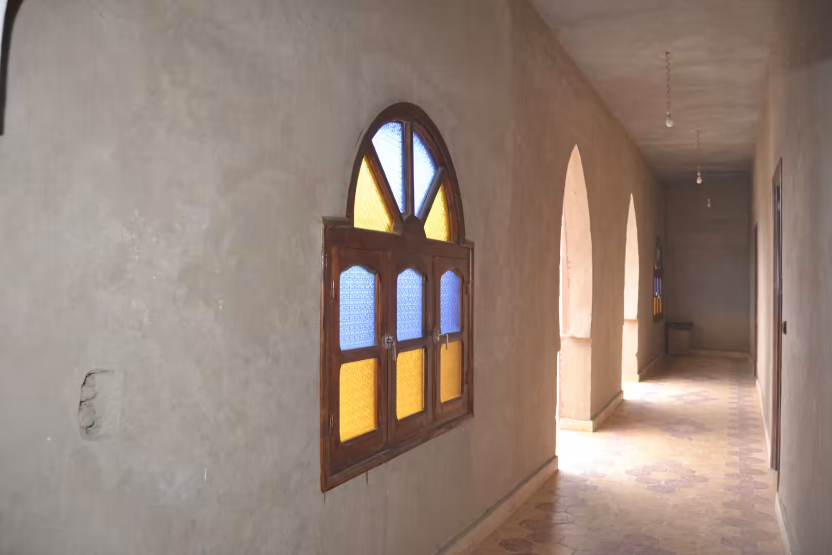 Hallway with stained glass window and arches