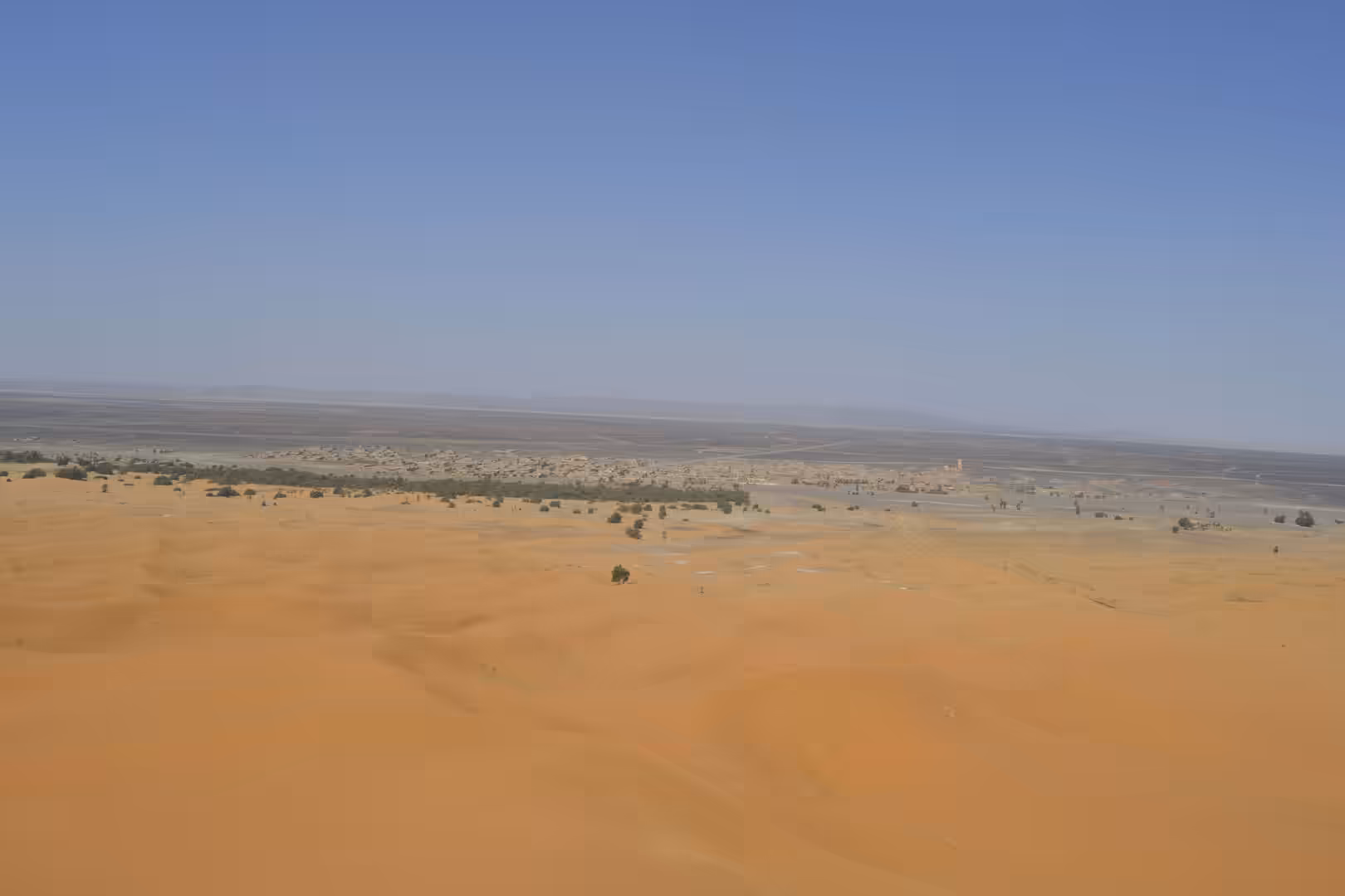 View from Sahara dune toward Merzouga oasis