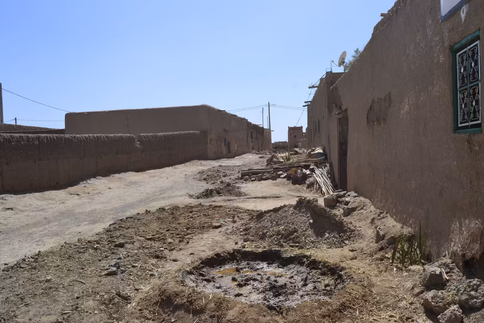 Unpaved street in desert village with adobe houses