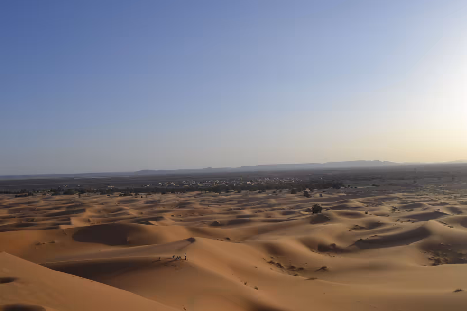 View of Sahara dunes with Merzouga village in distance