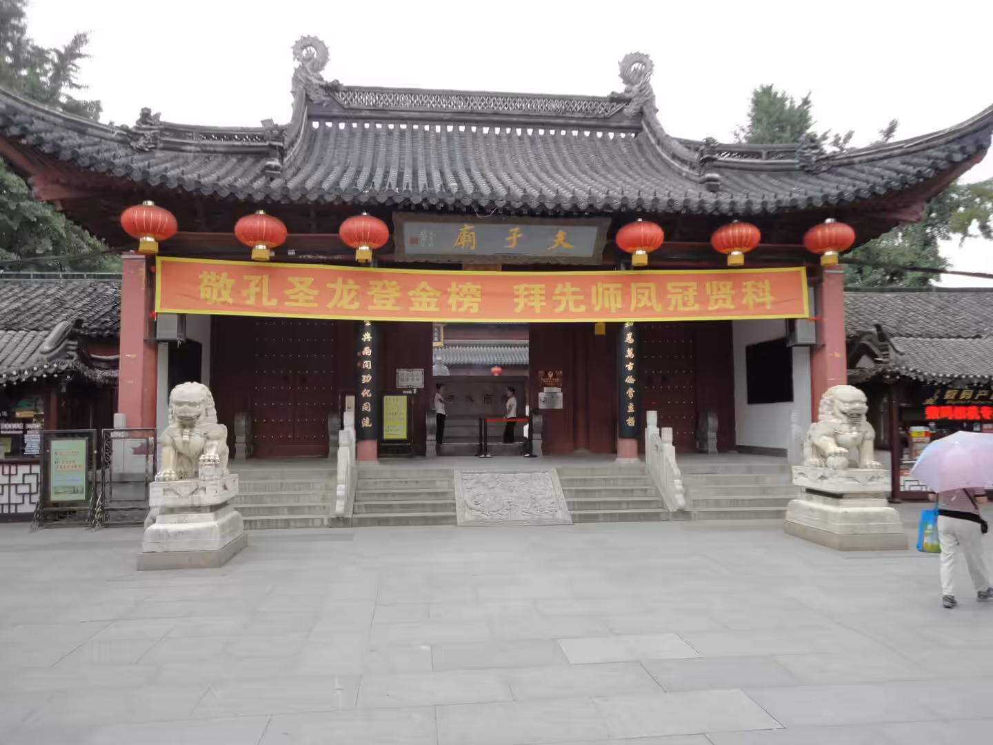 Entrance gate of the Confucius Temple with stone lions, red lanterns, and ceremonial steps