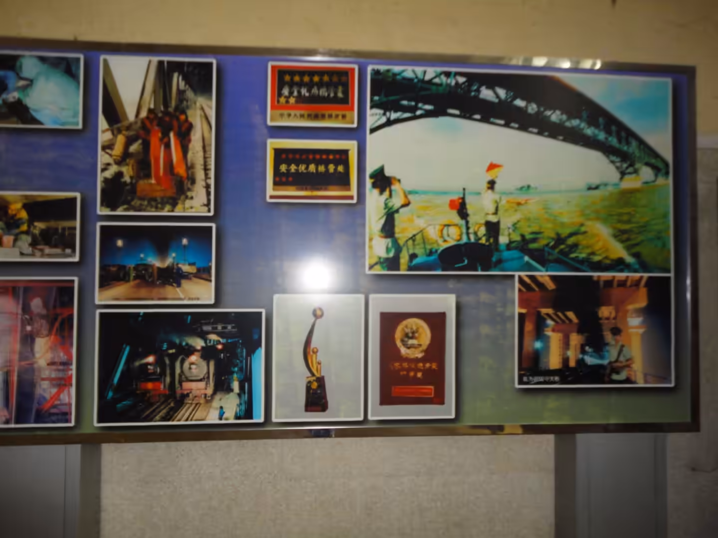 Exhibition panel displaying historical photographs, awards, and operational scenes related to the Nanjing Yangtze River Bridge