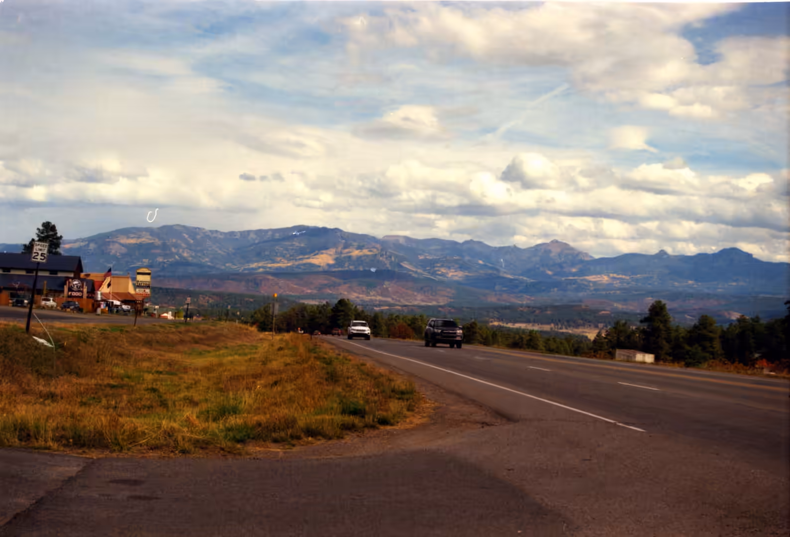 Cars on a highway toward a mountain range