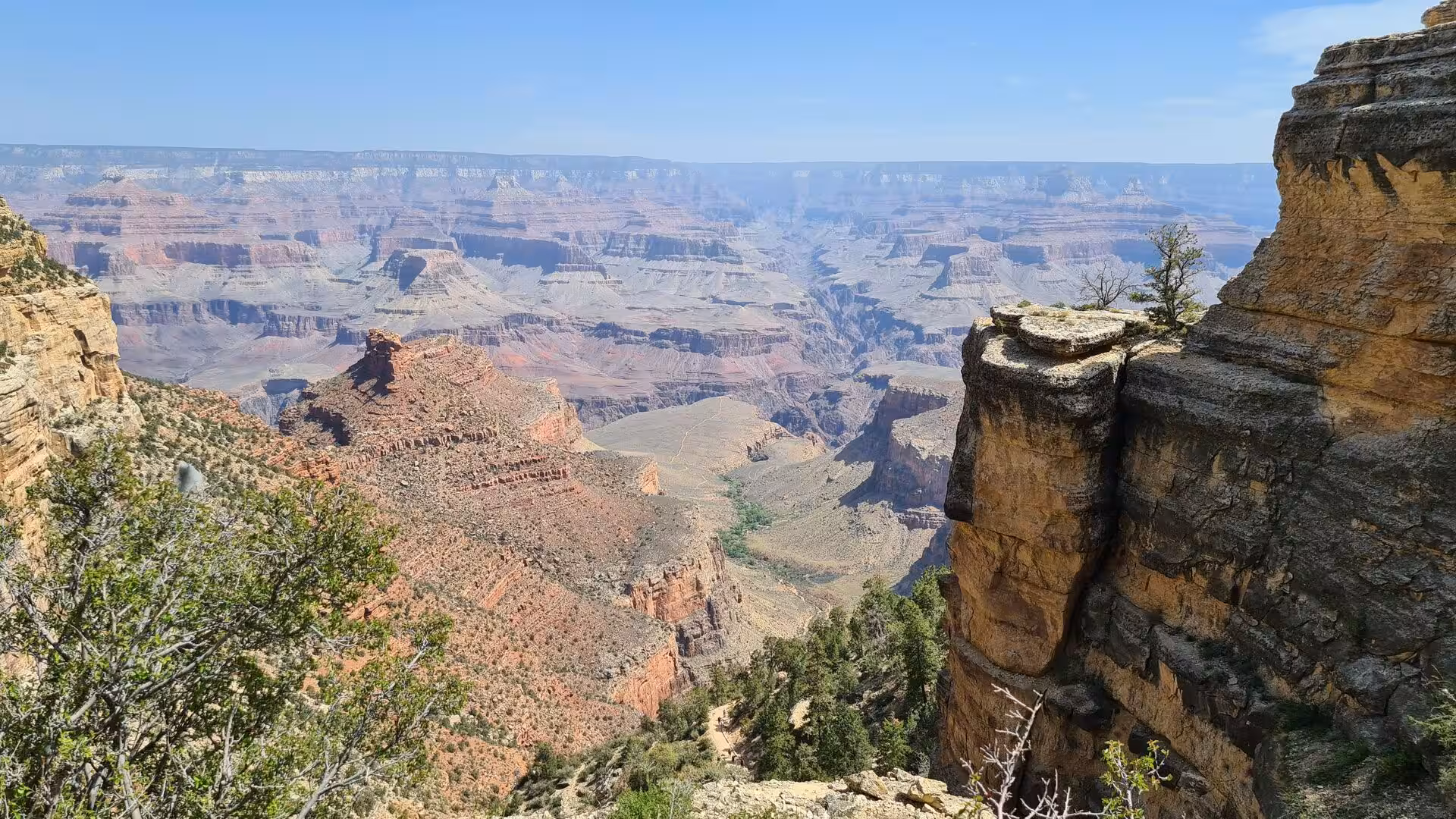 An enormous gorge of horizontal red rock strata fills the view.
