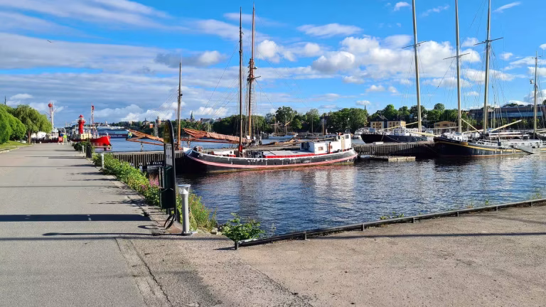 Tall sailing ships rest at quiet wooden piers along the waterfront.
