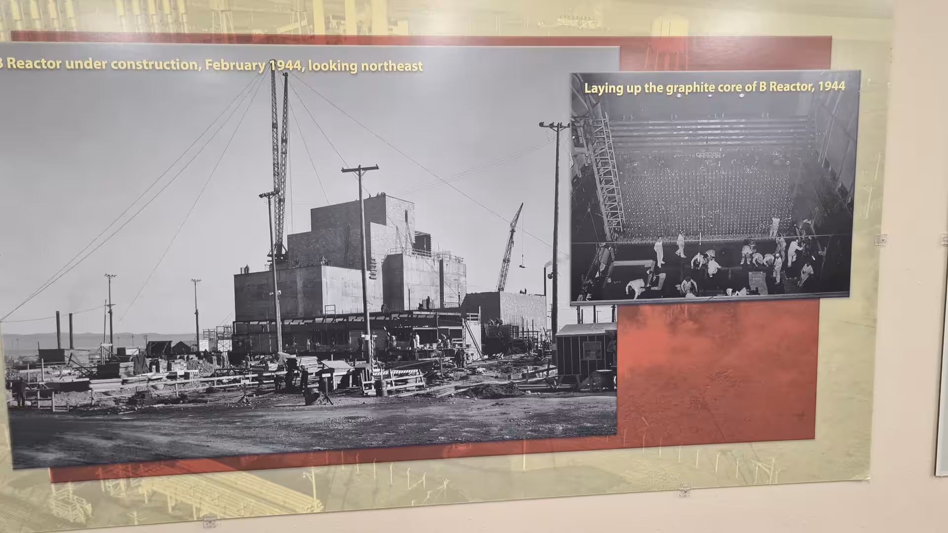 Archival museum display showing construction of the Hanford B Reactor and workers assembling the graphite core in 1944