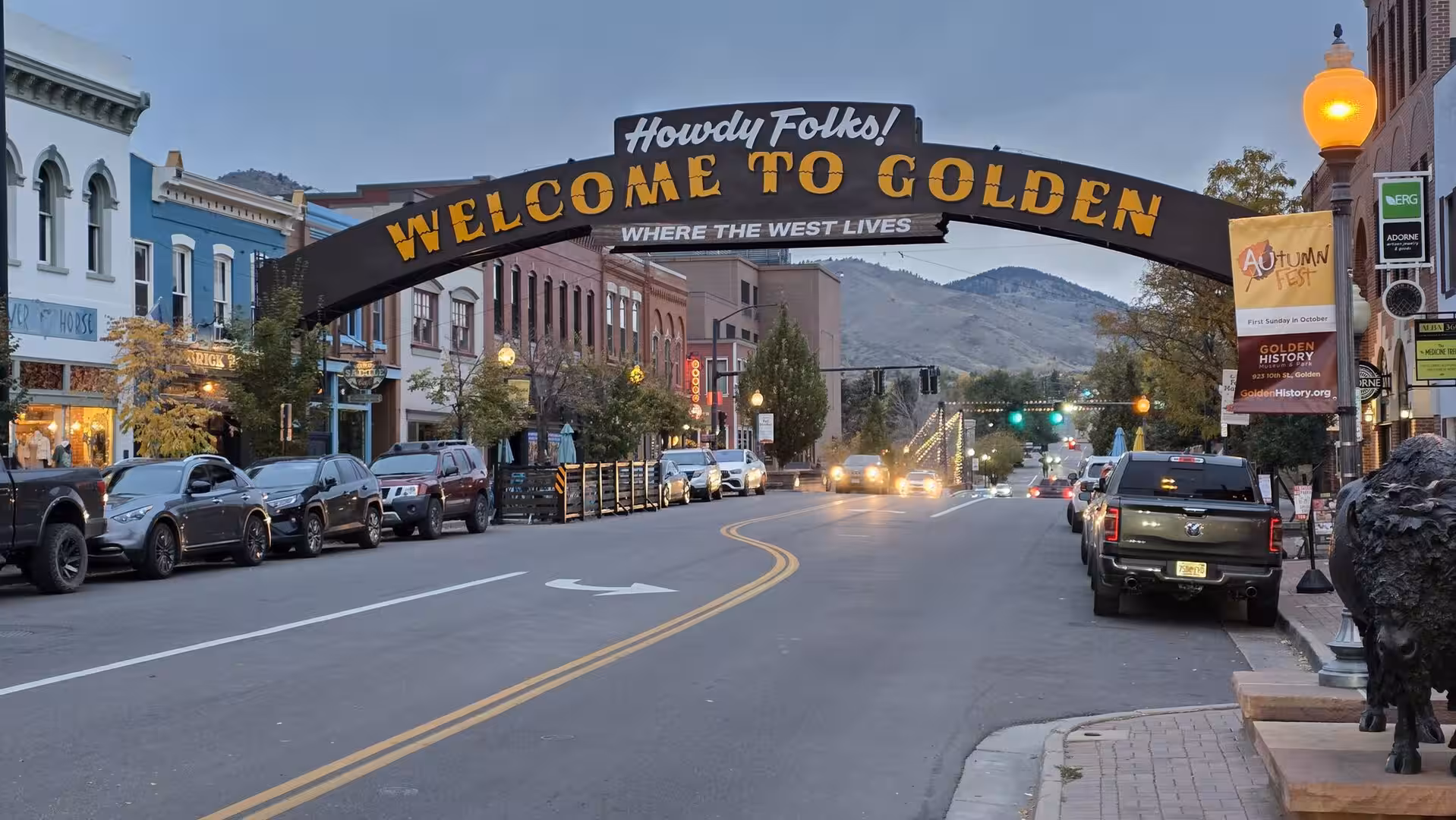 Historic downtown Golden Colorado with welcome arch and mountain backdrop at dusk