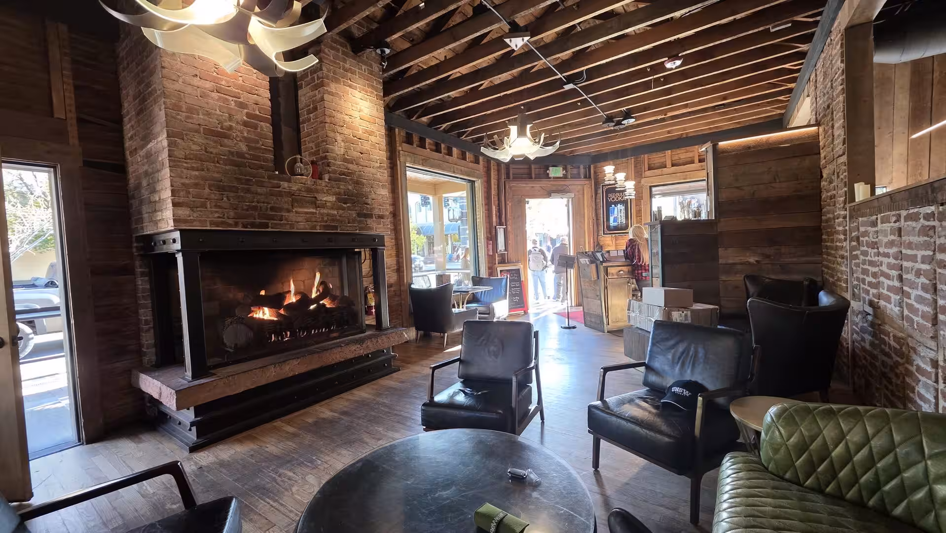 Cozy mountain lodge lounge with fireplace, exposed brick walls and leather chairs