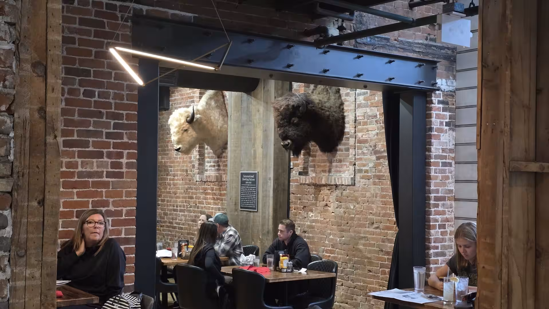 Rustic restaurant interior with exposed brick walls and mounted bison displays in Colorado