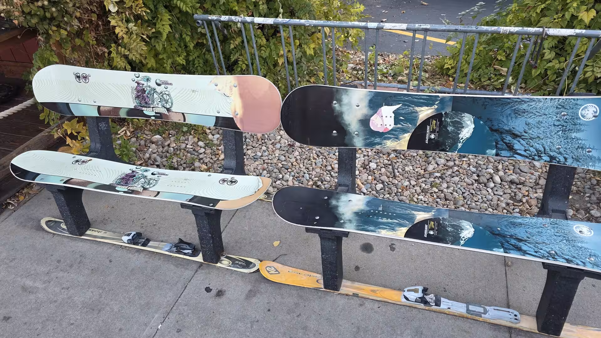 Skis and snowboards resting on outdoor benches near a mountain lodge in Aspen, Colorado
