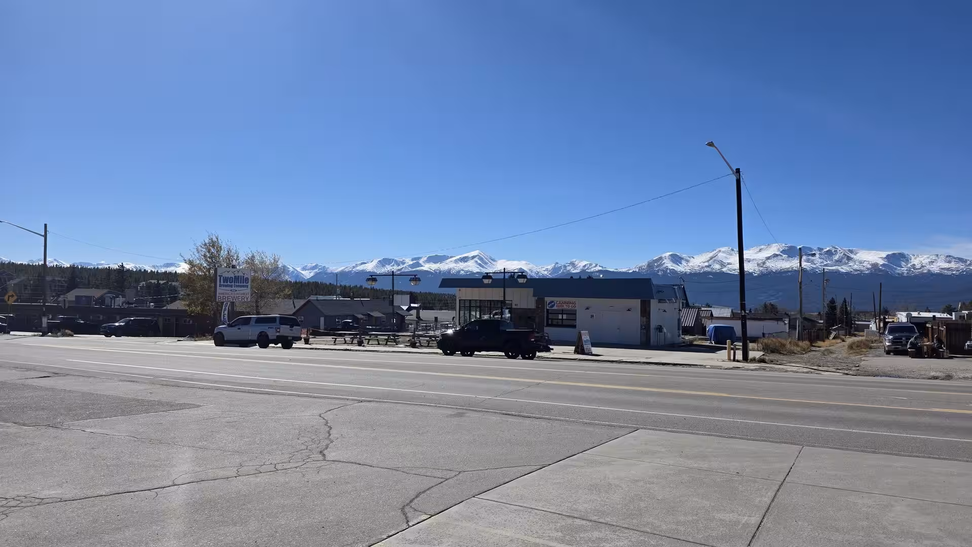 Snow-covered Rocky Mountains rising behind a roadside scene in Frisco, Colorado