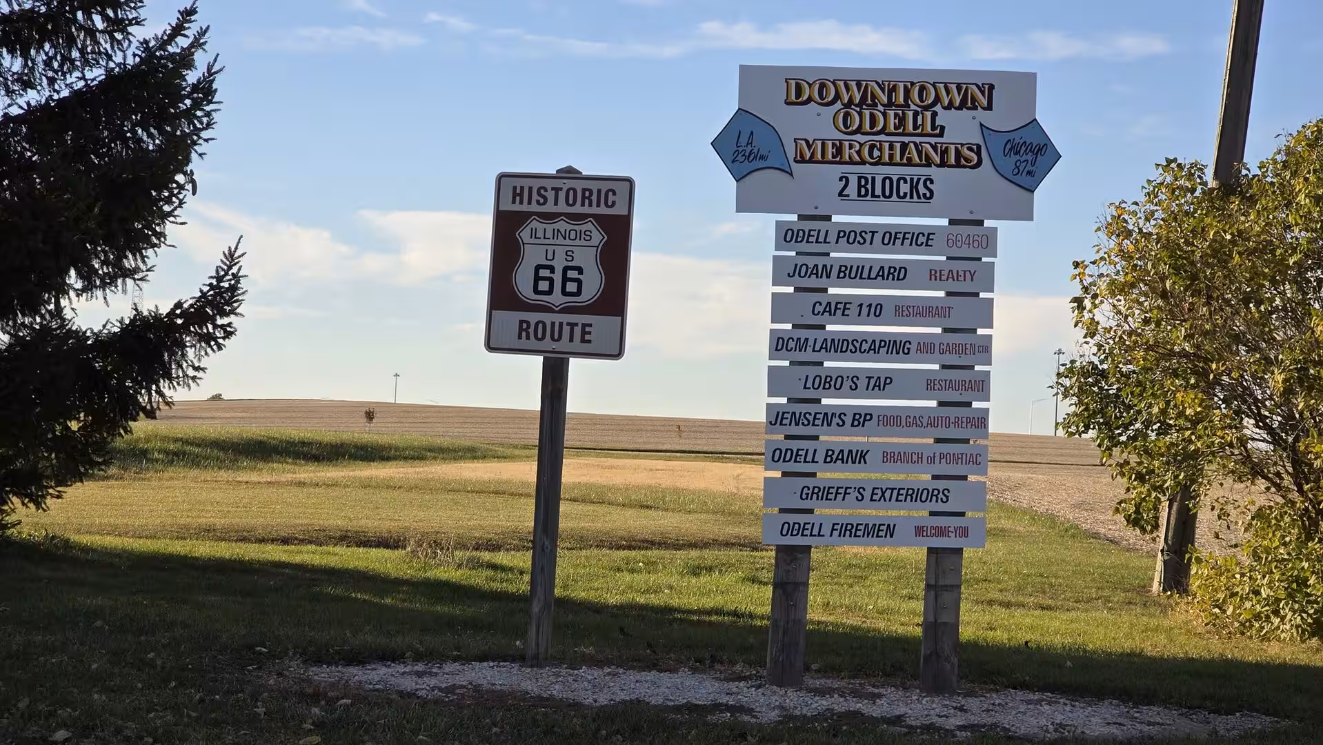 Historic Route 66 sign and downtown merchant directory in Odell, Illinois.