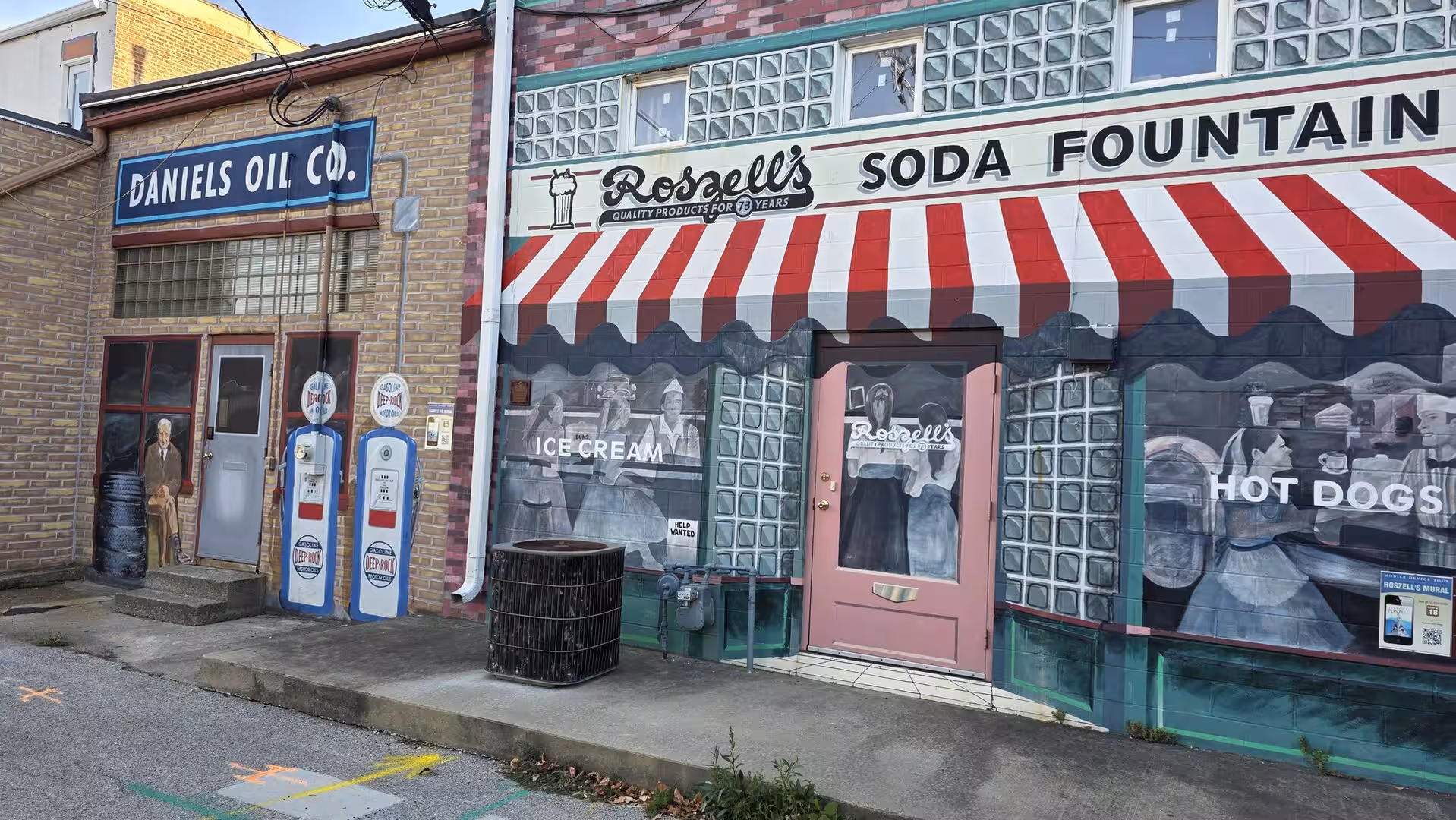 Vintage Route 66 style mural with old gas pumps and soda fountain storefront in Illinois.