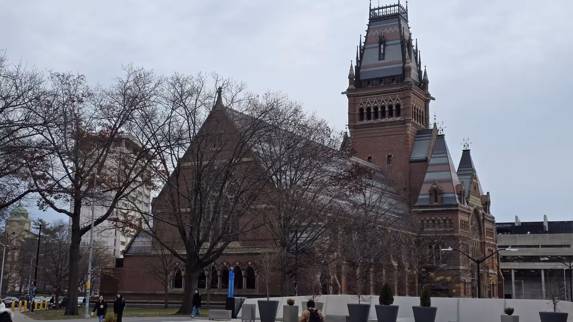 Historic red-brick church building with a tall Gothic Revival tower surrounded by leafless trees in downtown Boston on an overcast day.