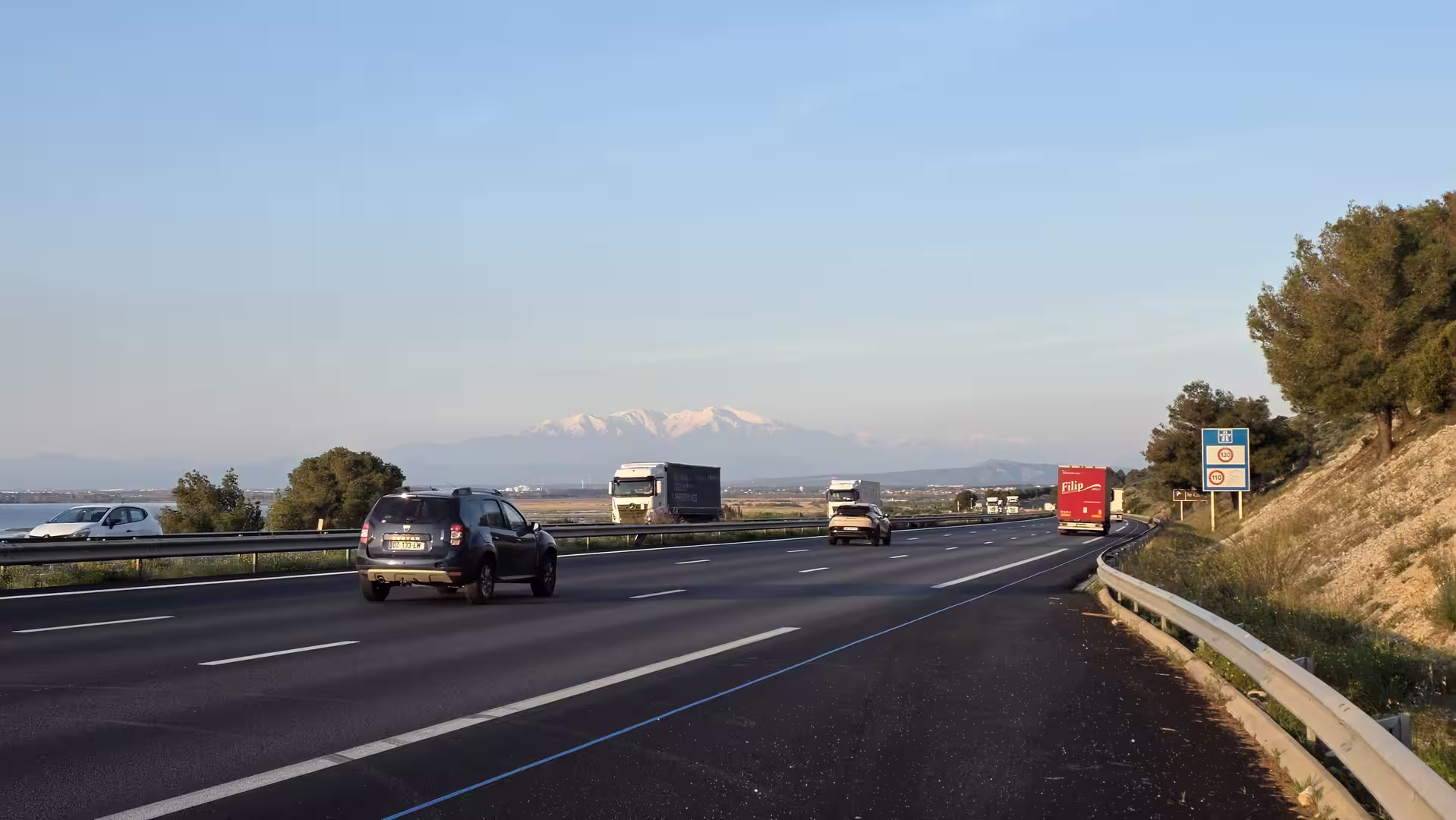 Motorway in northeastern Spain with the snow-covered Pyrenees visible in the distance.